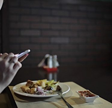 stock-video-75216323-the-girl-in-the-red-dress-sits-at-a-table-in-the-restaurant-and-use-the-phone